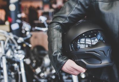 革ジャンを着けてヘルメットを持っている人