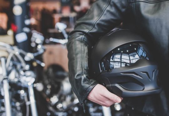 革ジャンを着けてヘルメットを持っている人